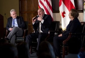 Group of three speakers on stage.