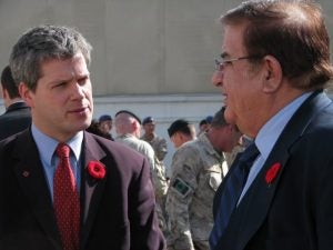 Two men in suits have conversation.