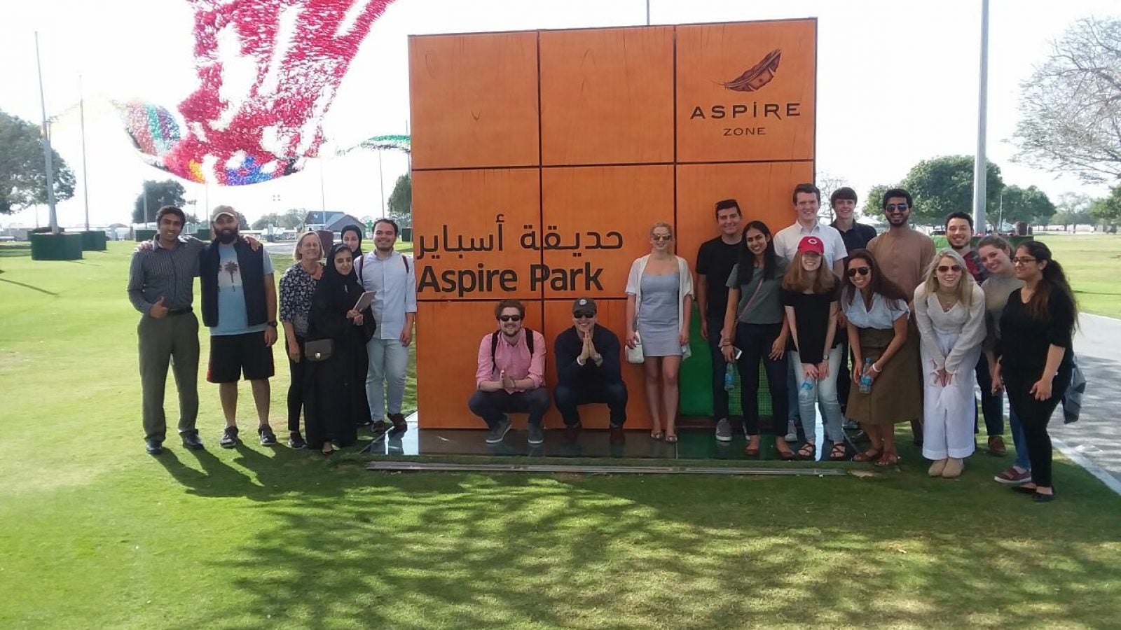 Group of people pose for photo in front of park sign.
