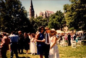 Group of three people pose outside during a college graduation.