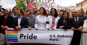 Men and women hold Pride banner.