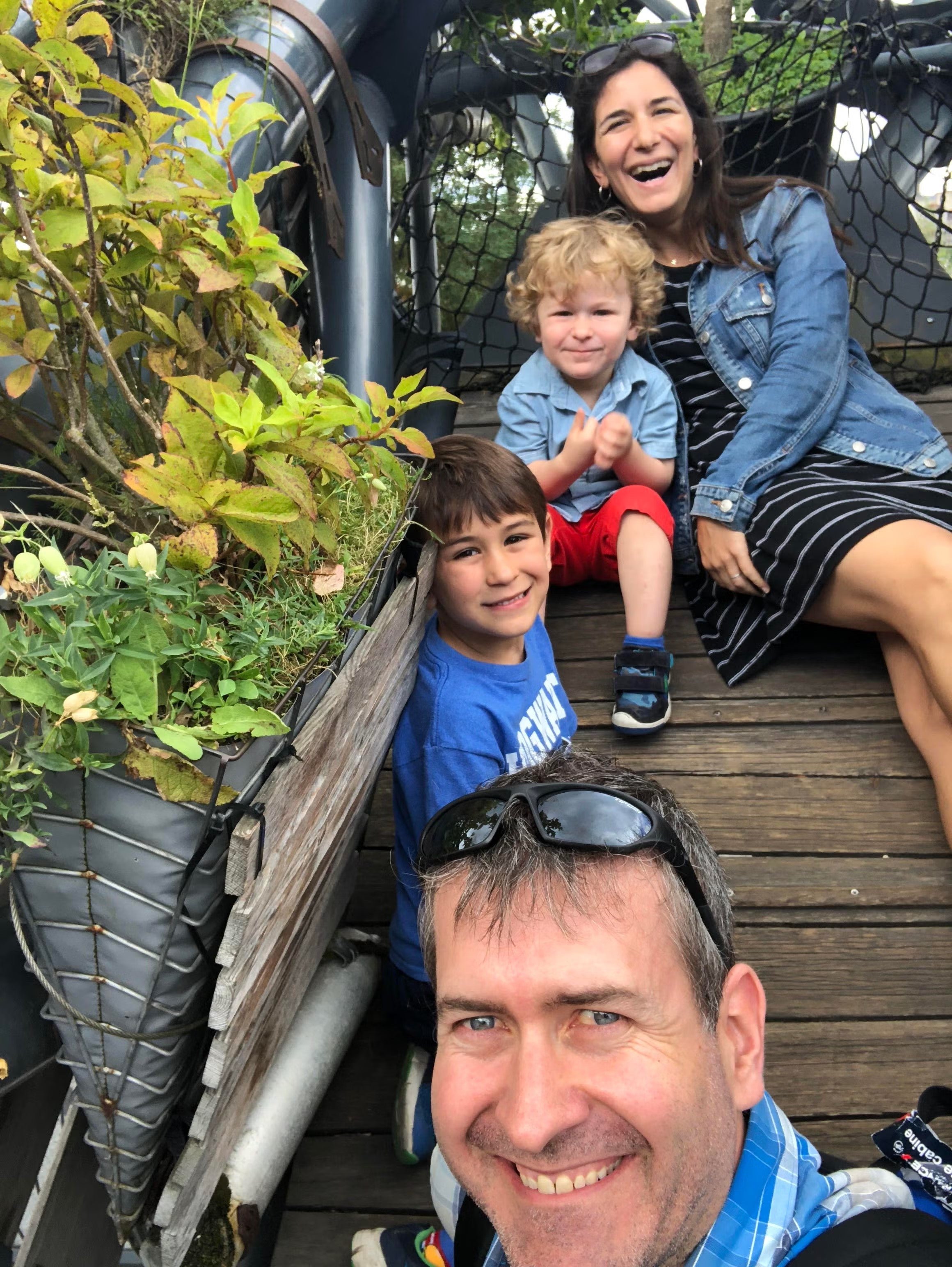 Photo of Elizabeth Grimm Arsenault, her kids, and husband, sitting on stairs outside.
