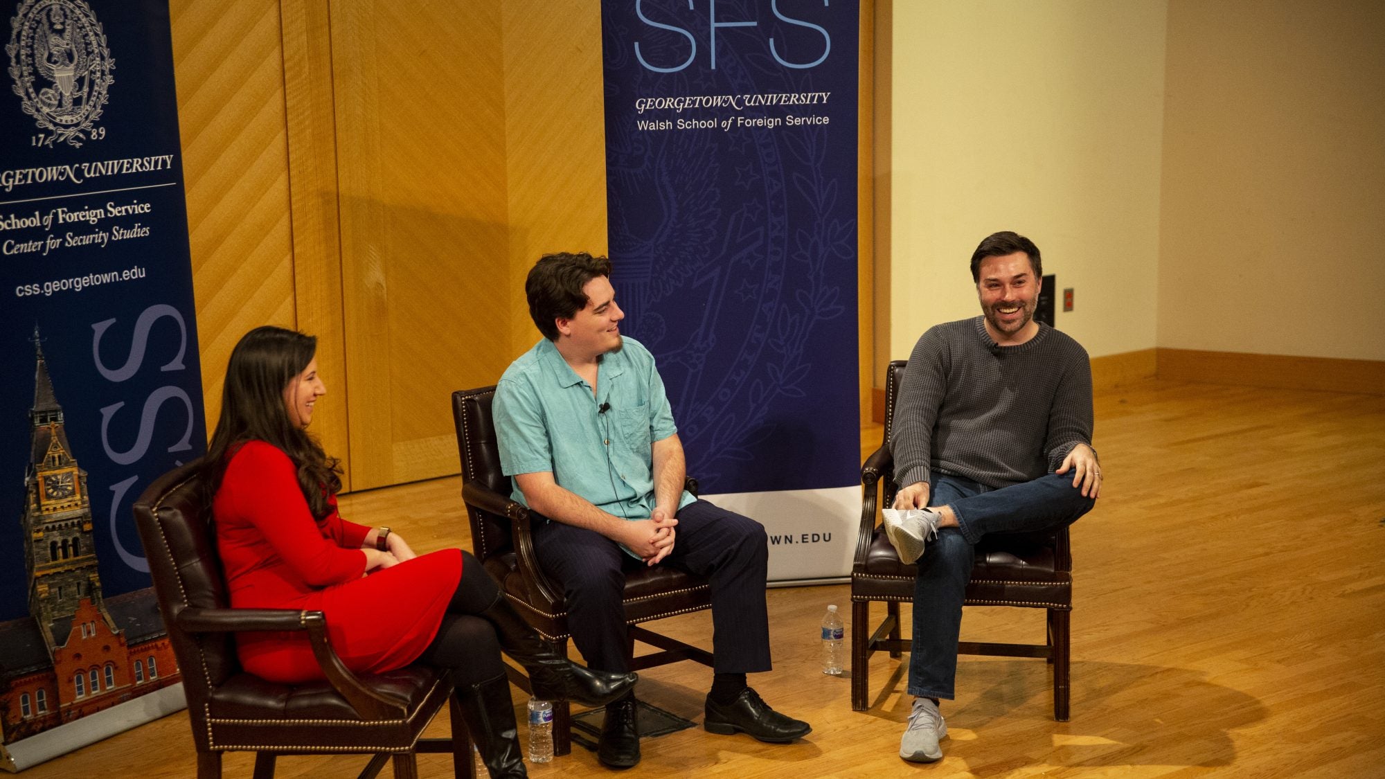 Three panelists sit in conversation on a stage.