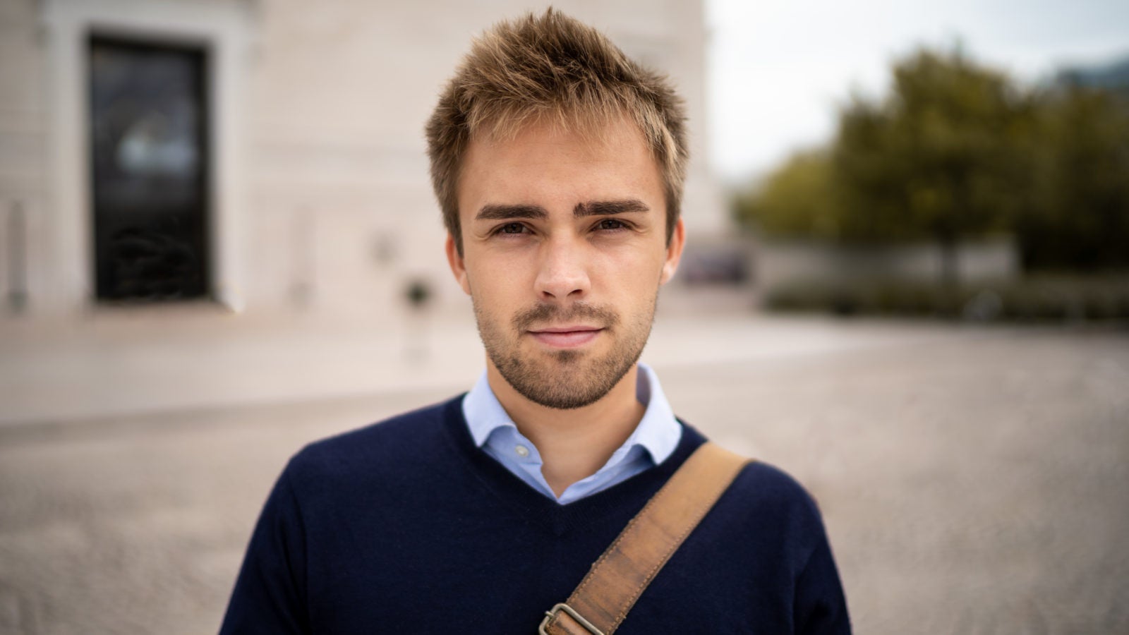 Man stands in front of building.