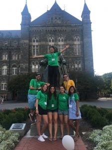 Group of people pose for a photo in front of a statue.