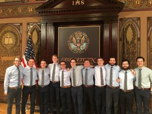 Group of acapella singers pose for a photo on stage.