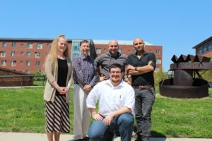 Group of five people pose for a photo.