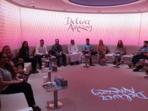 Group of people seated on circular couch.