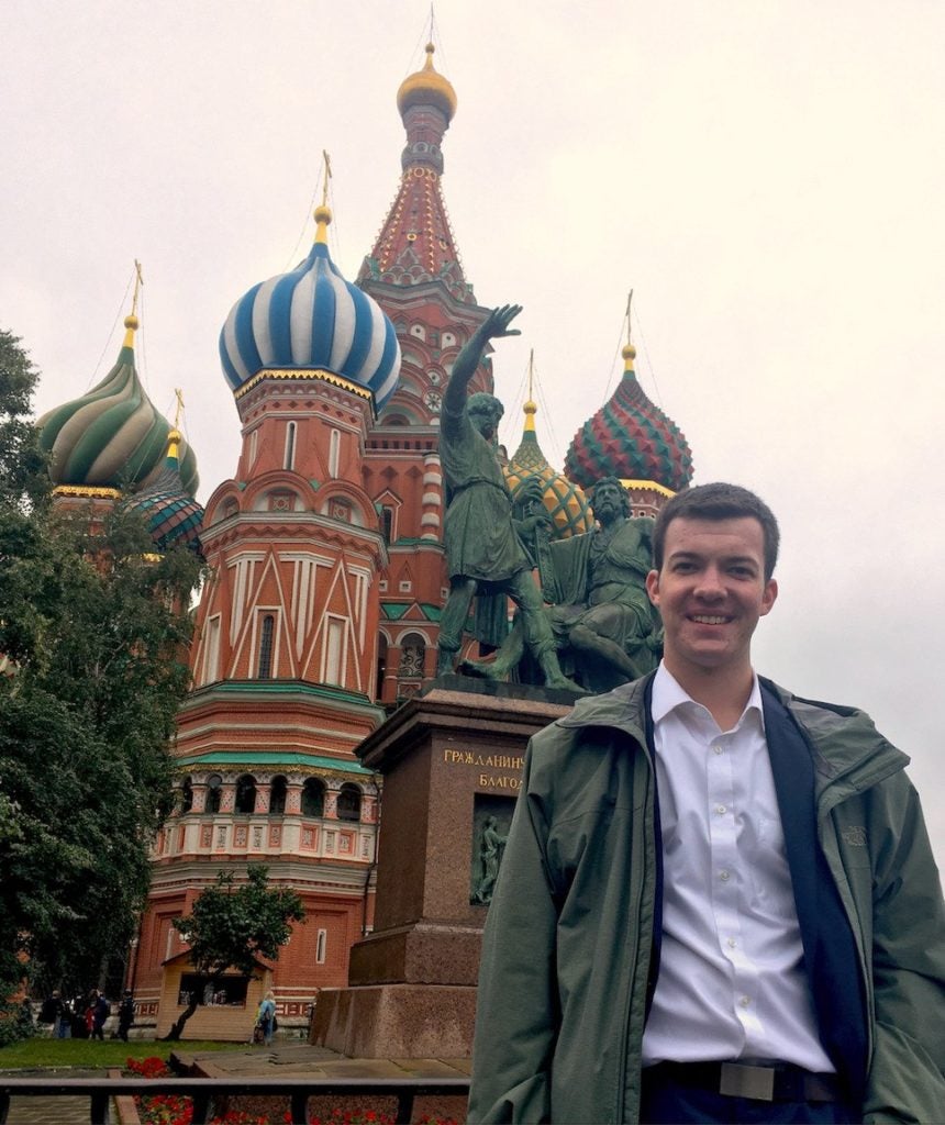 Man poses for photo in front of Saint Basil's Cathedral.