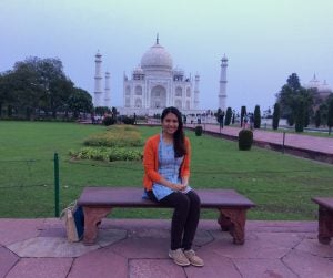 Woman seated in front of Taj Mahal.