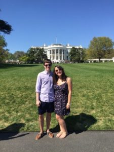 Man and woman pose in front of the White House.