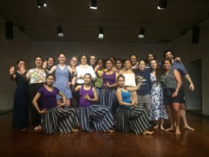 Group of people and performers pose for a photo.