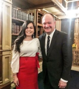 Man and woman pose for photo in library.