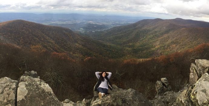 Woman posing on top of mountain.