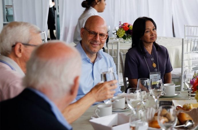 Dean Hellman sitting with alumni at reunion