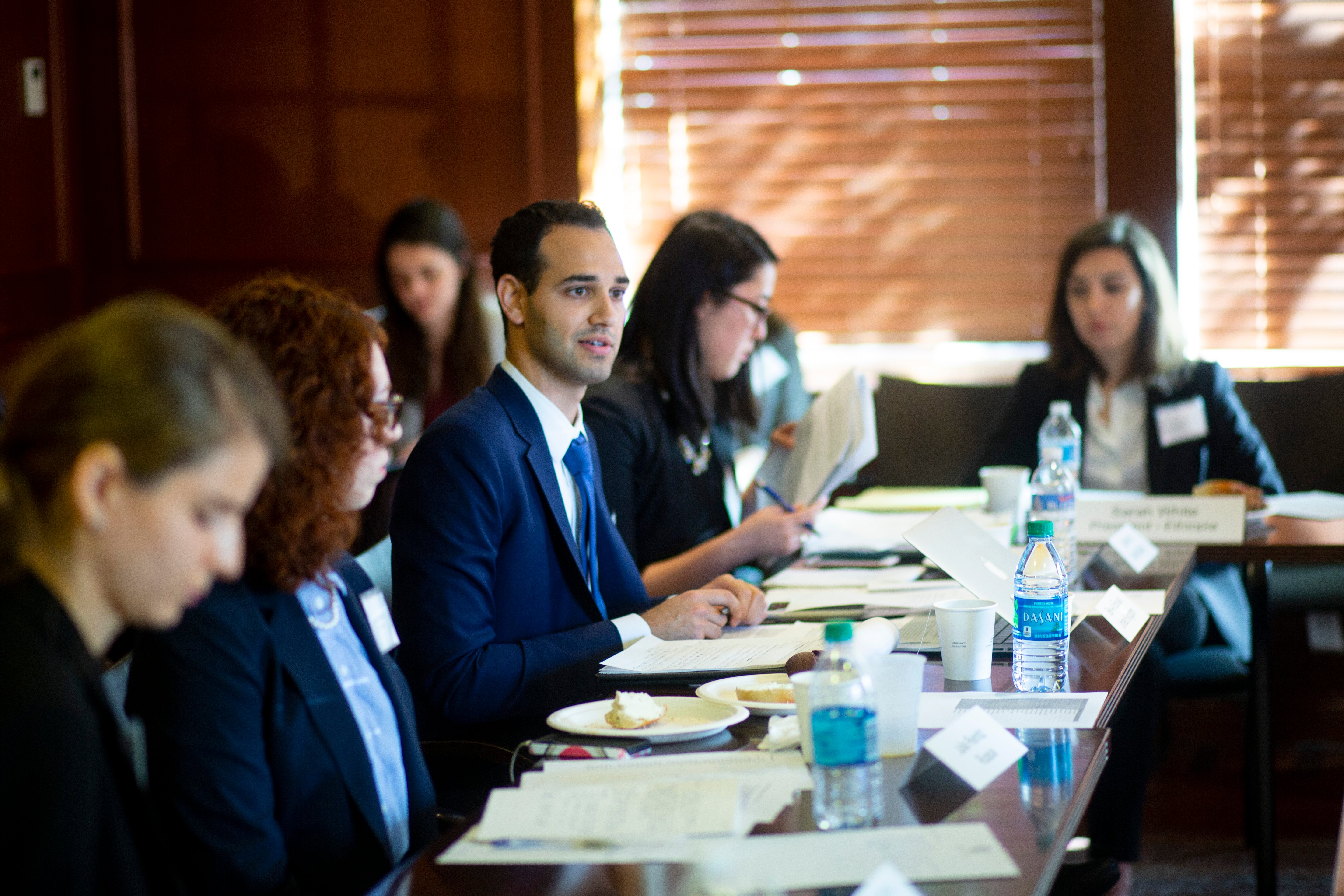 Students in suits at a table.