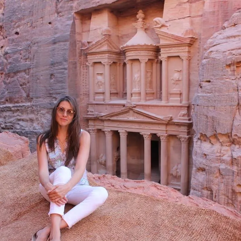 Aliya Mazza traveling abroad during Arabic language immersion program, wearing white pants, sleeveless top, and sunglasses.