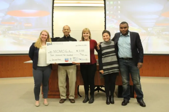 Three women and four men who won second place as a team in the Social Innovation Lab competition, holding $3,500.00 check.