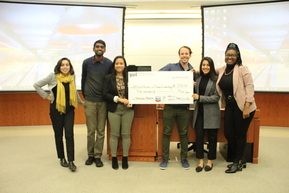 A team of two men and four women who won honorable mention in the Social Innovation Lab competition, holding $500.00 check.