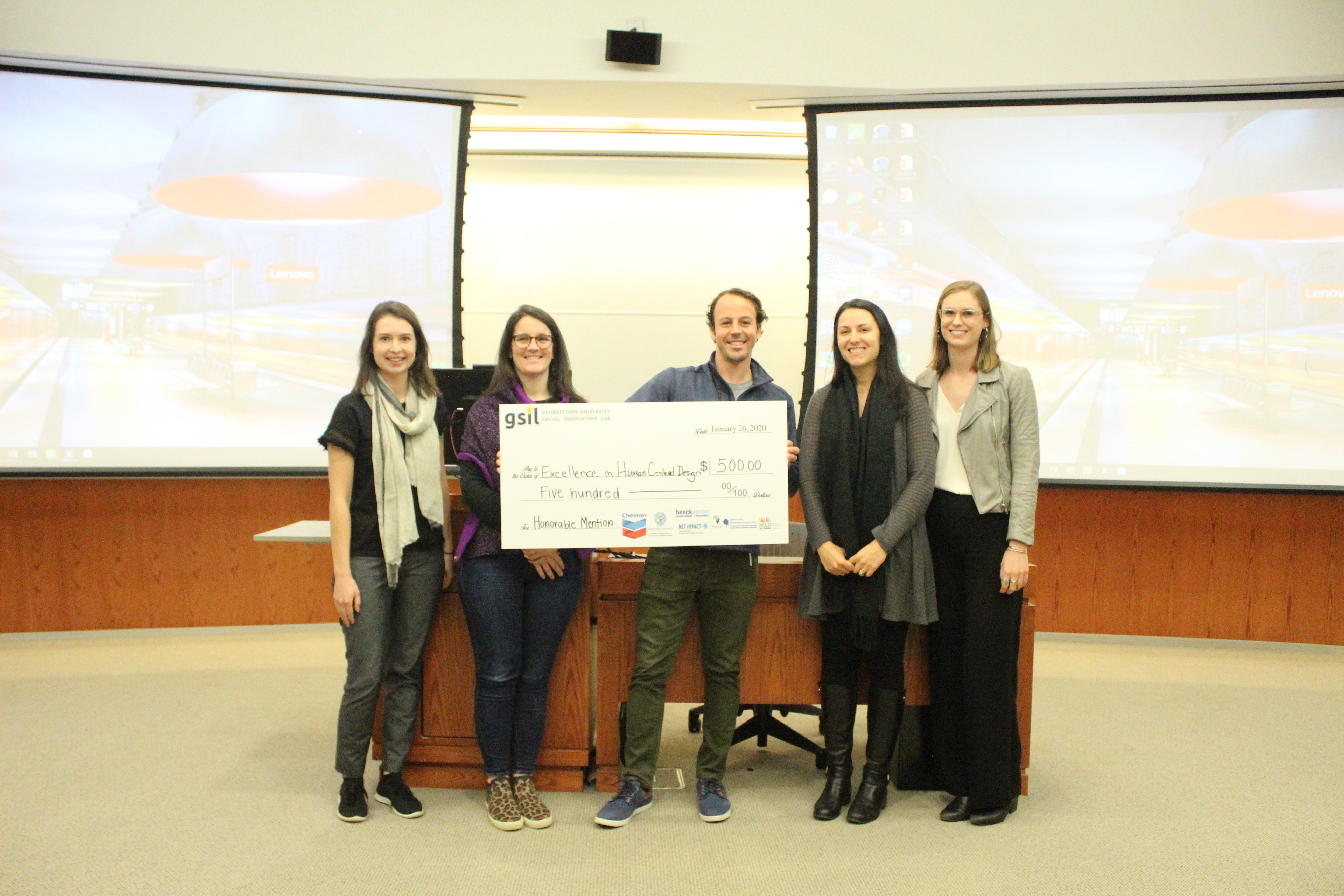 A team of four women and a man, who won honorable mention in the Social Innovation Lab competition, holding $500.00 check.