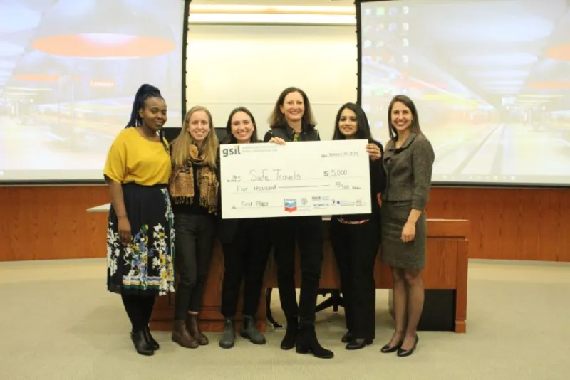 First place team of six students from Social Innovation Lab competition stand together in a row after competition holding a $5,000.00 check.