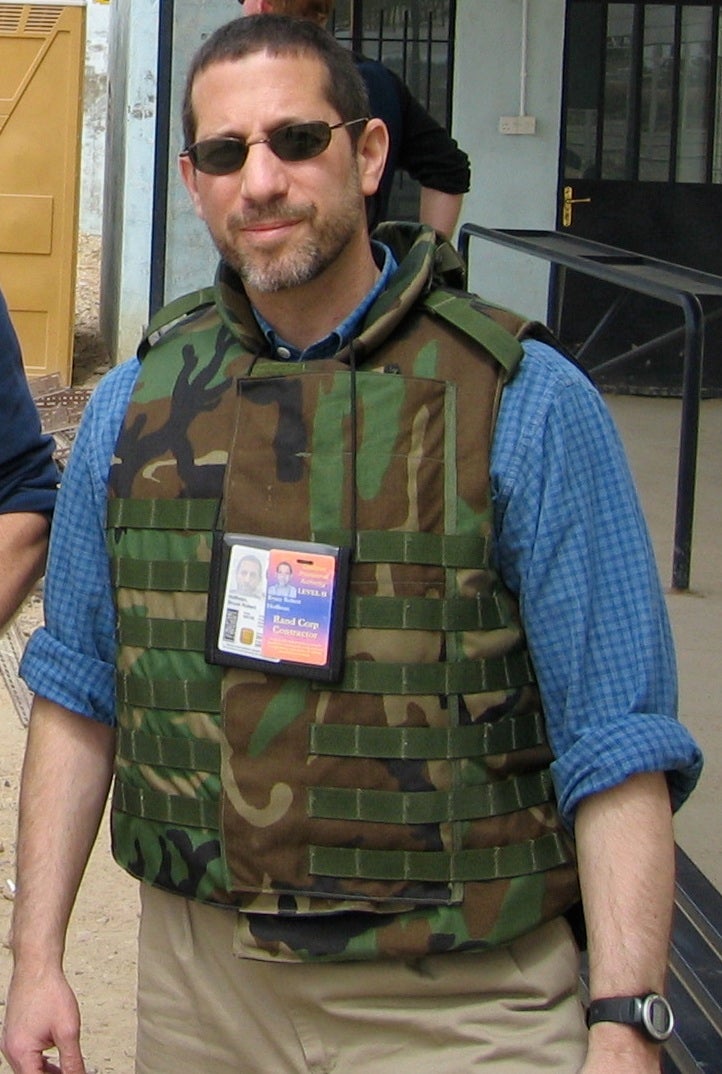 Prof. Hoffman wears his credentials and a camouflage bulletproof vest. 