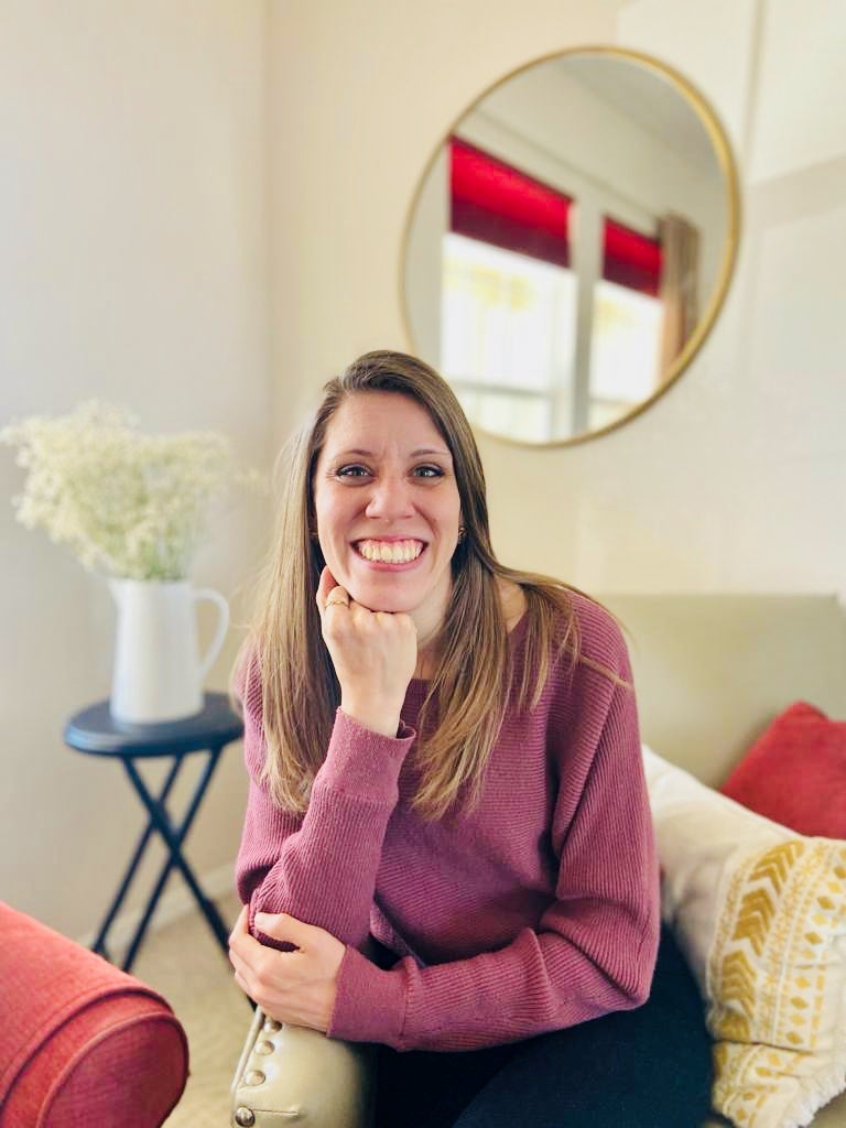 Profile photo of Caris Boegl. She is propping her chin on her arm and is pictured in a bright living room.