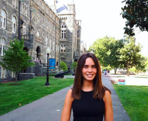 Molly Daly (SFS'21) stands and smiles along the sidewalk in front of Healy Hall on Georgetown's campus.