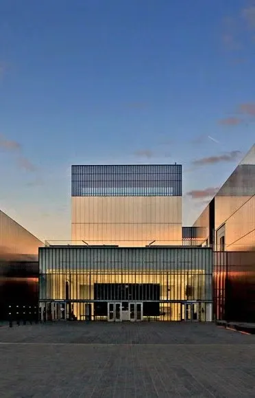 Museum building entrance at sunset. The museum entrance architecture is flat, metal, and boxy.