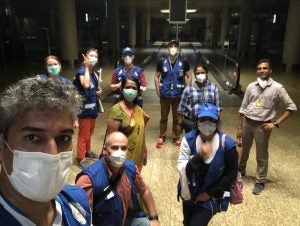 Razick and consular staff take a selfie at night in an empty airport.