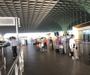 American evacuees wearing masks and waiting to enter an airport