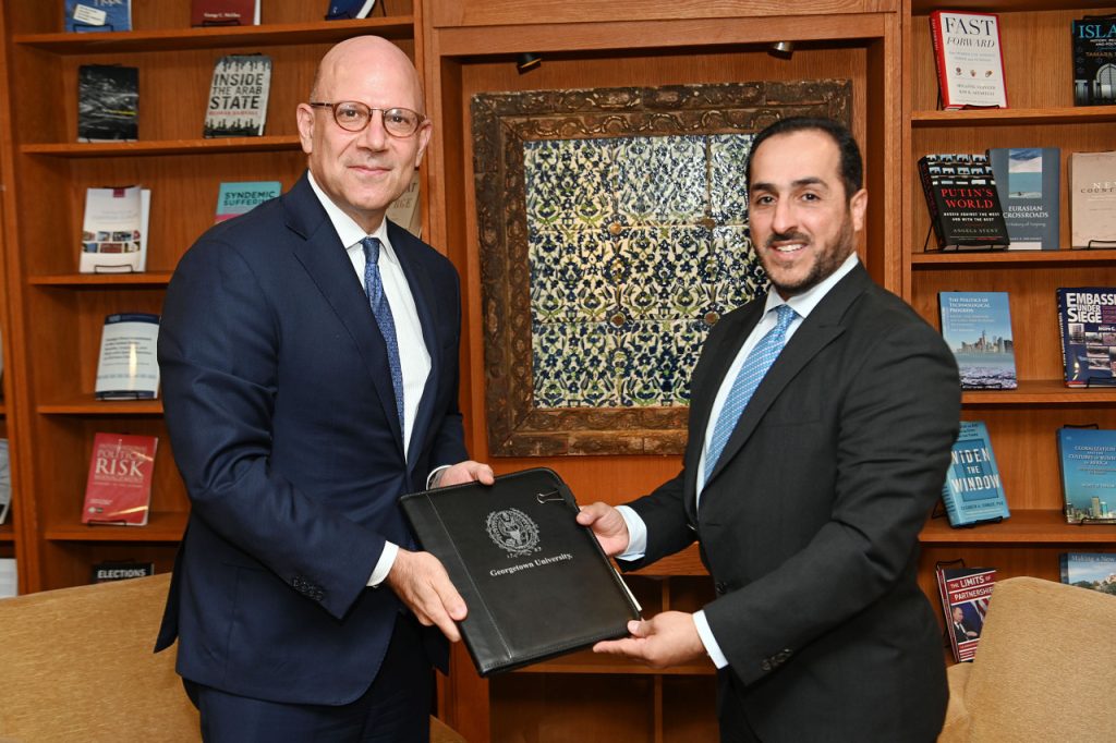 Dean Hellman and Dr. Abdulaziz Bin Mohammed Al-Horr, the Director of the Qatari Ministry of Foreign Affairs Diplomatic Institute hold folder.