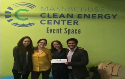 Rahul Mitra with three people standing in front of Massachusetts Clean Energy Center Even Space sign on lime green wall