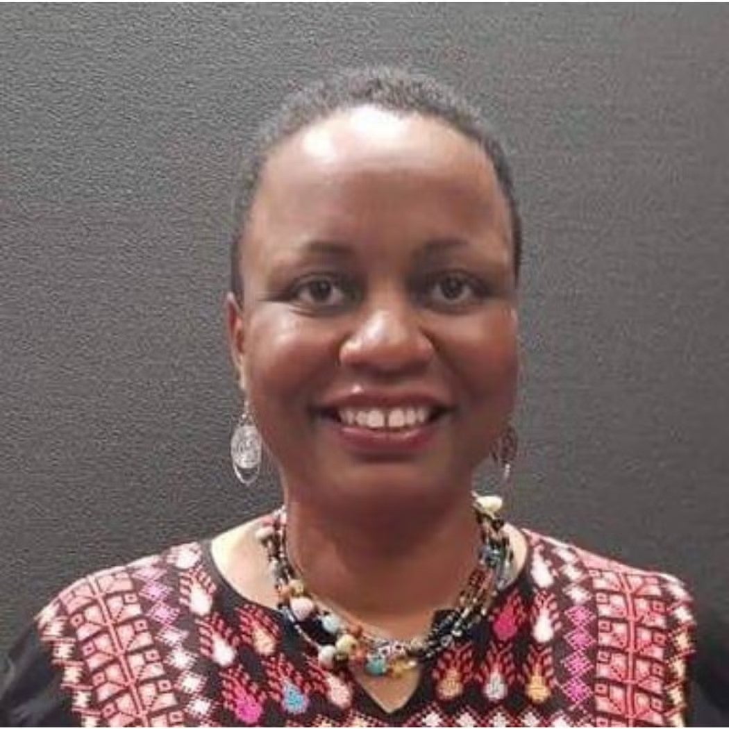 Headshot of Michelle Denise Carter wearing red and black printed top.