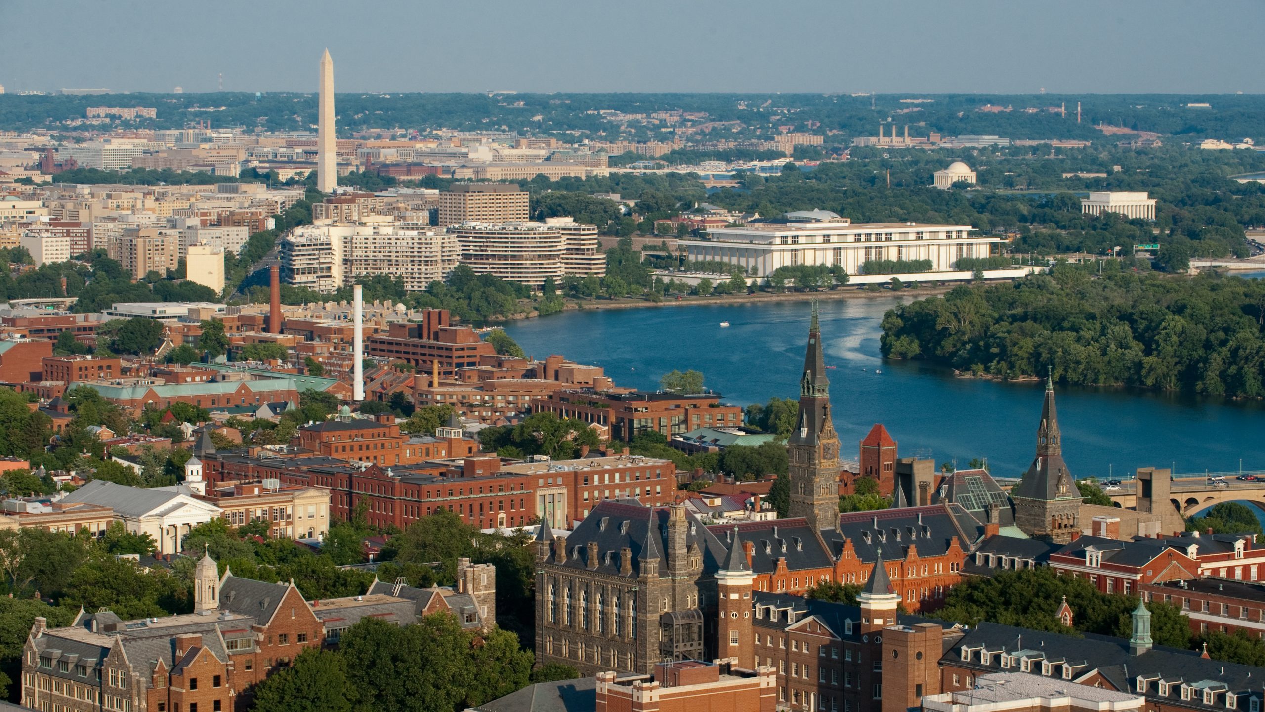 Aerial shot of Georgetown's campus in DC with Washington monument prominent in background