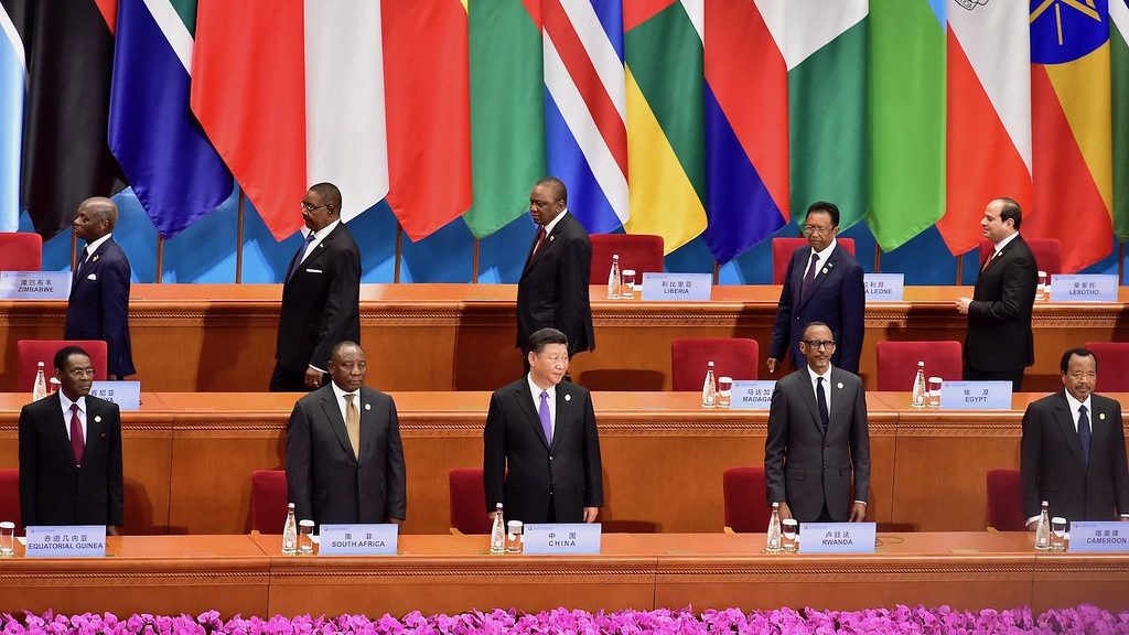 Numerous African national leaders meet with China's President Xi Jingping. They stand as conference desks with national flags displayed behind them.