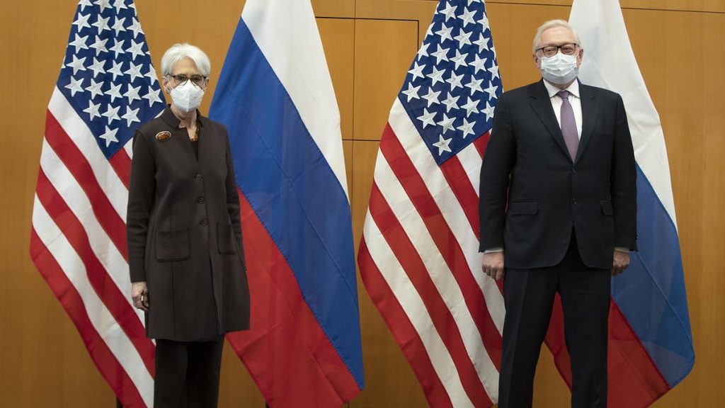 Wendy Sherman and Sergei Ryabkov pose in front of U.S. and Russian flags