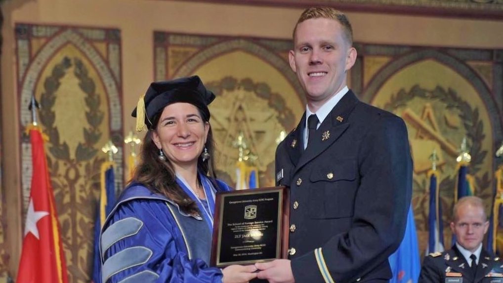 Photo of Jack Moore (SFS'16, SSP'17) in military dress uniform accepting an award from Georgetown University Prof. Elizabeth Grimm in Gaston Hall.