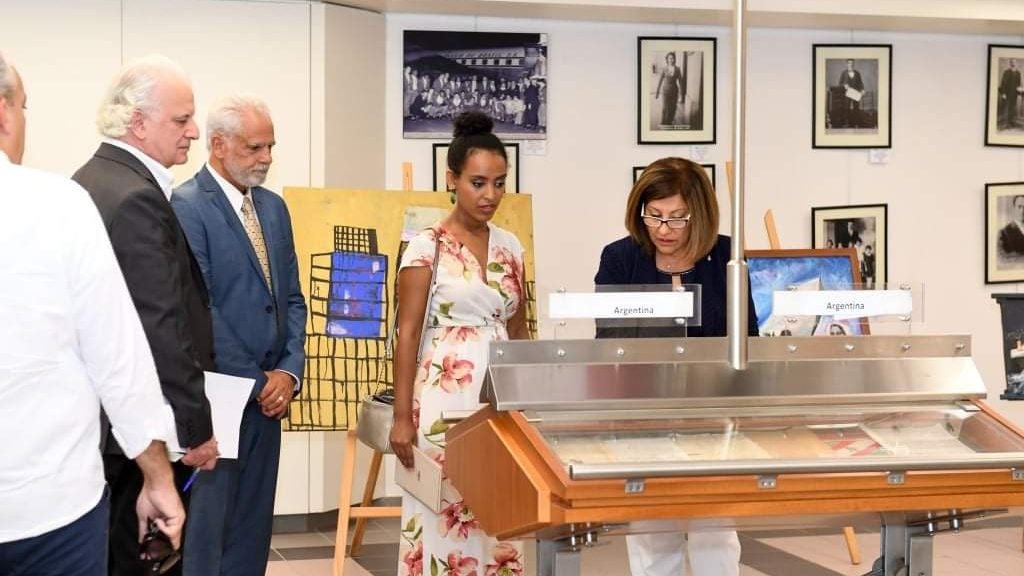 Photo of Hermila Yifter (SFS"15) and others looking at a musuem exhibit or archive.