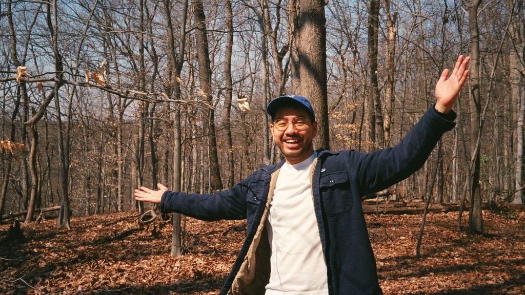 A photo of Andreyka Natalegawa (MASIA'22) smiling outdoors in a forest.