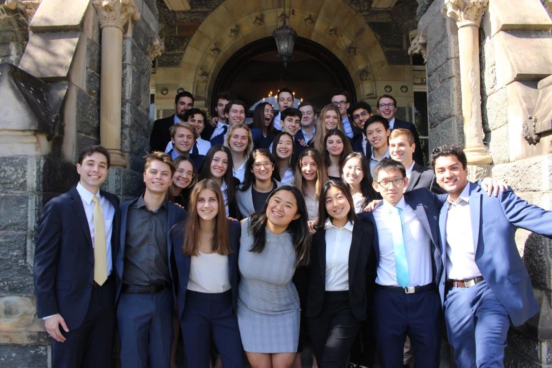 Student pose in formal business attire pose in front of Healy Hall