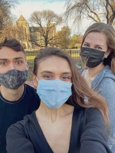 Three students, masked, pose for a selfie.