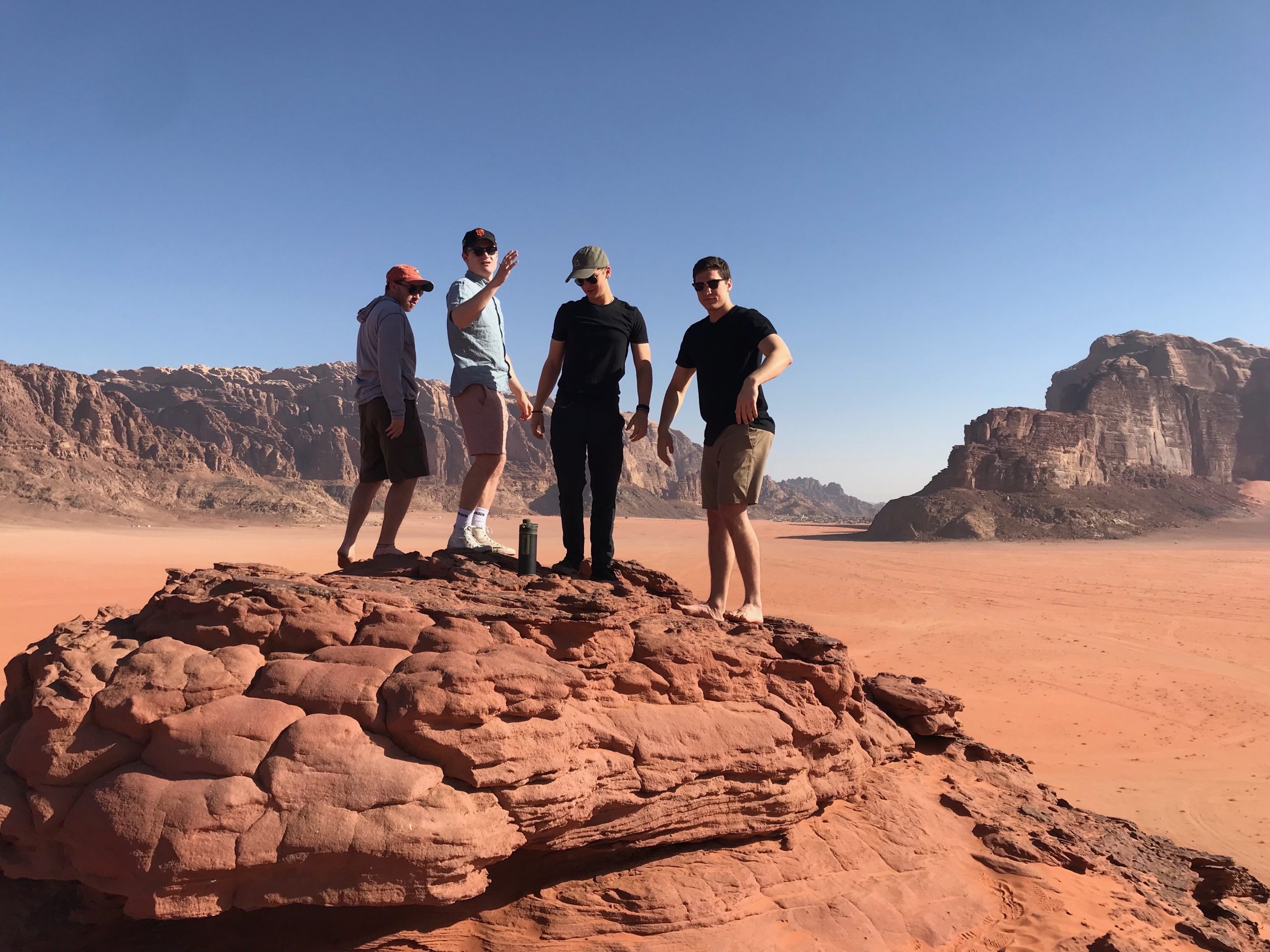 Four people posing for a picture in Wadi Rum in Jordan