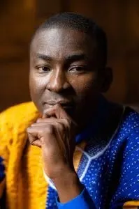 Abdul-Washeru Alhassan in blue and gold long-sleeve top.