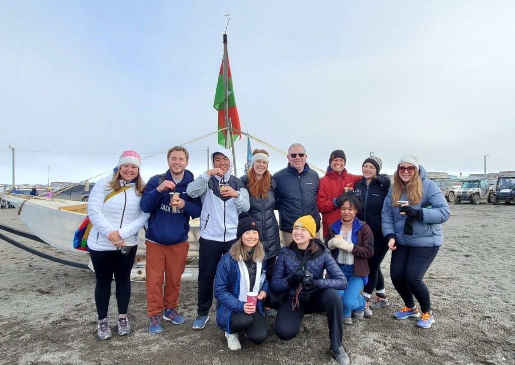 The C-Lab poses for a group photo in front of a boat used for whaling.