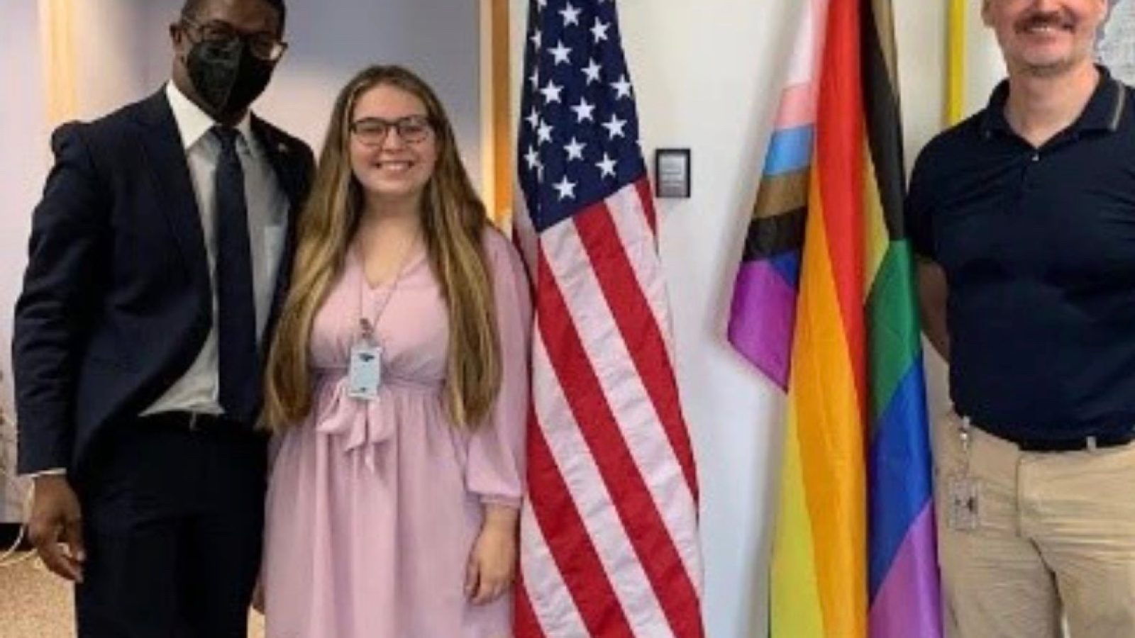 Gwyneth Murphy takes a photo with two colleagues to commemorate hanging up the LGBTQI+ Progress Flag in the State Department office