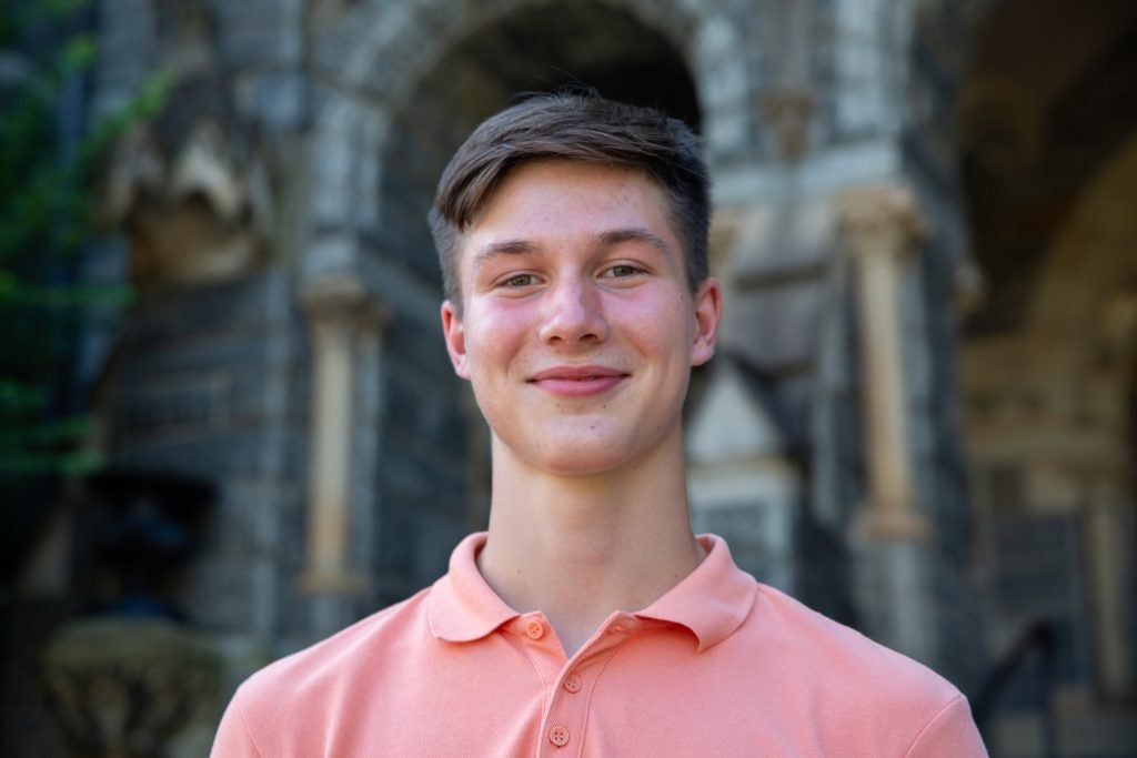 Headshot of Kyryl Myronenko smiling in front of Healy Hall