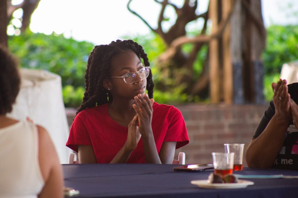 A participant seated at a table claps.