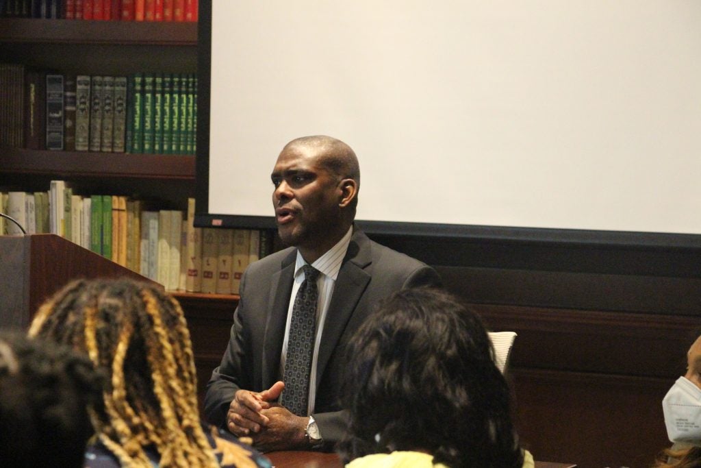 Amb. Derek Hogan sits at a board table