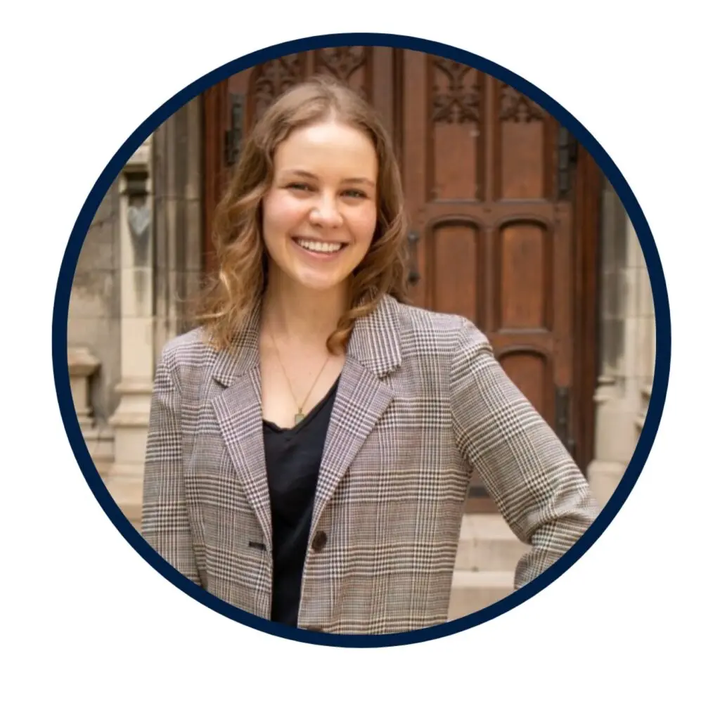Julianna Rossi Headshot, standing outside Healy Hall, wearing a gray blazer and black shirt.